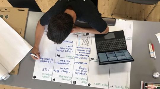 Junger Mann erstellt Businessplan