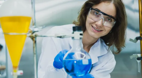 Das Bild zeigt eine junge Wissenschaftlerin bei der Laborarbeit.