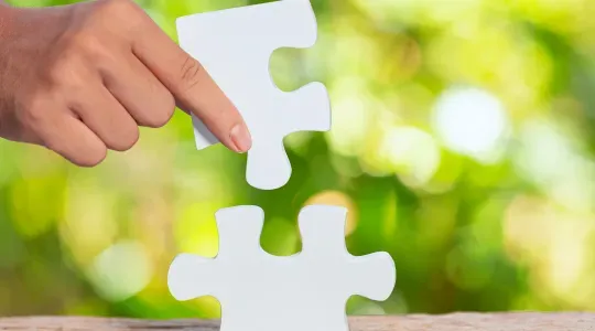 Hand mit Puzzleteil