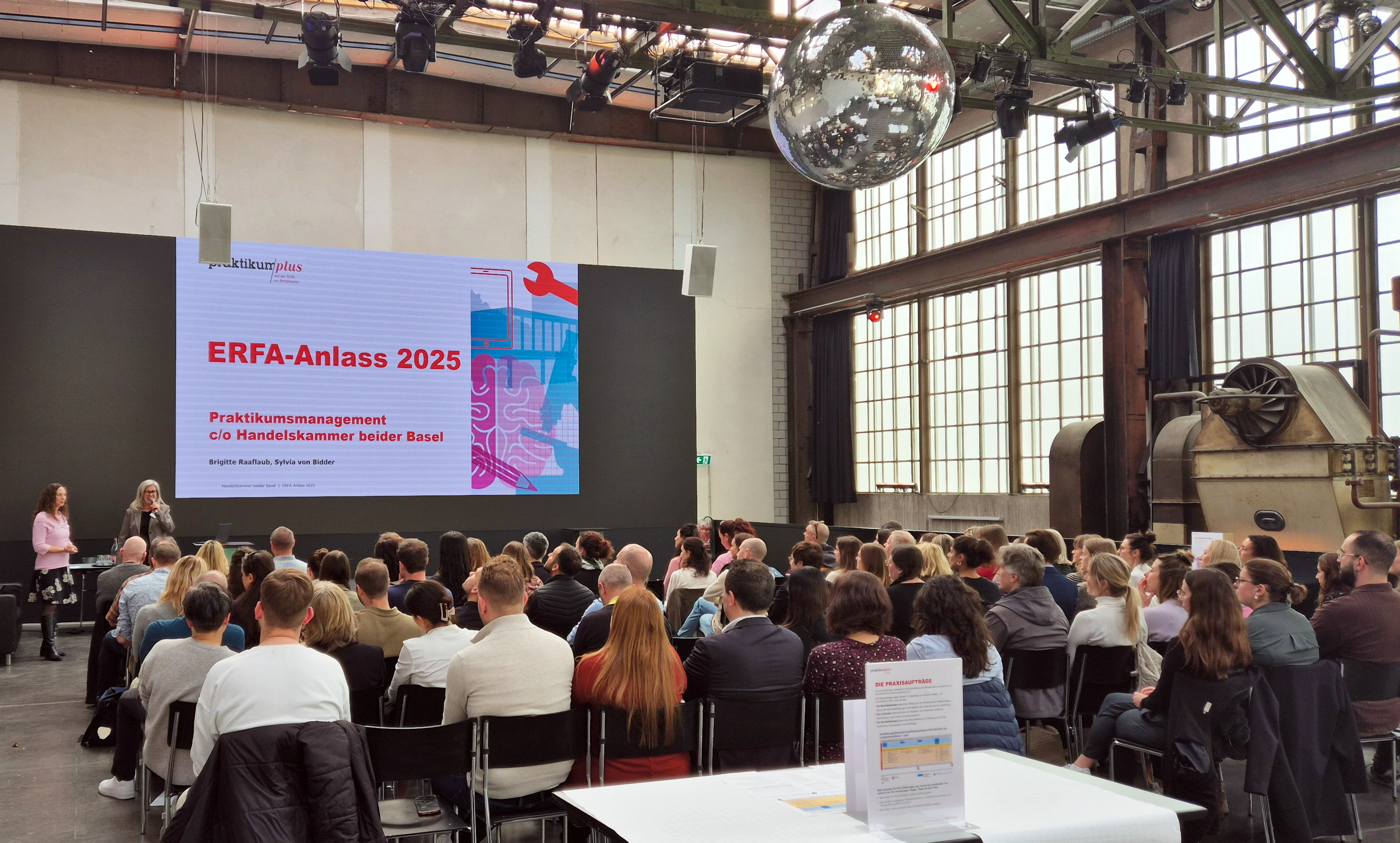 Tagung mit Publikum vor Leinwand in grossem Saal